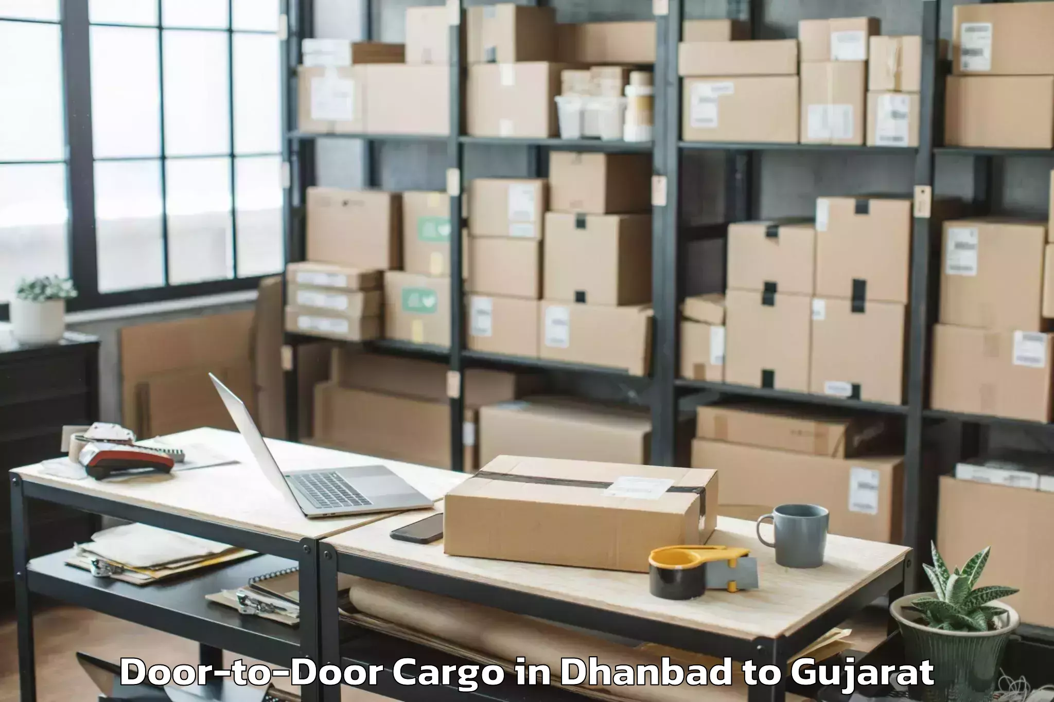 Dhanbad to Kamdhenu University Gandhinaga Door To Door Cargo